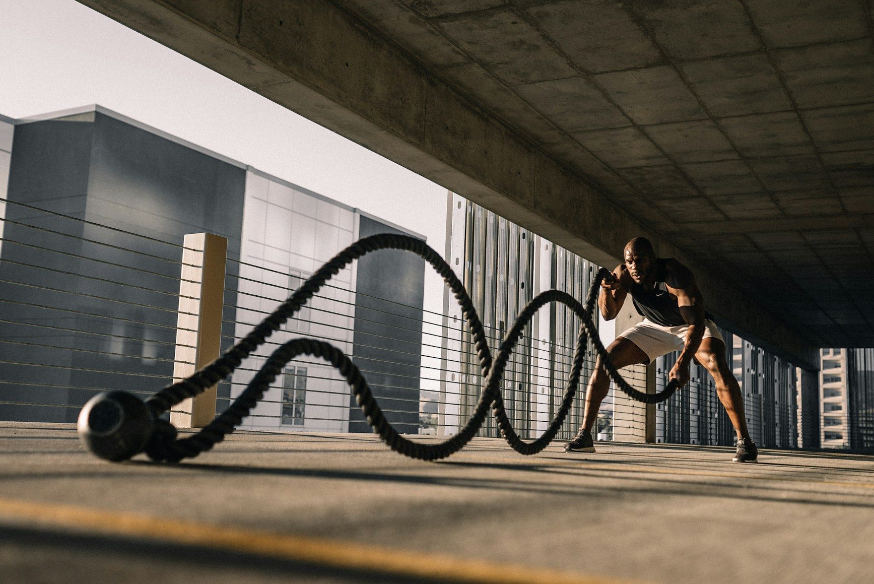 An athlete training with battle ropes representing discipline and compounding strength